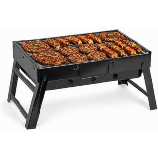 Barbecue portatile a carbone pieghevole nero con struttura a X aperto sul tavolo di legno da picnic con griglia cromata lucida in risalto